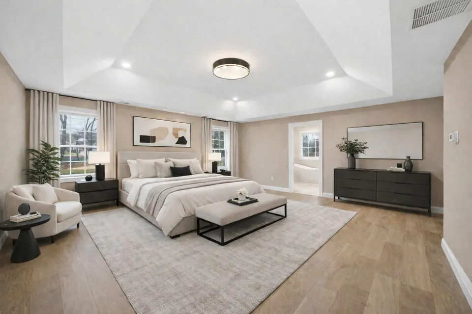 Primary bedroom with a tray ceiling and a door through to the bathroom