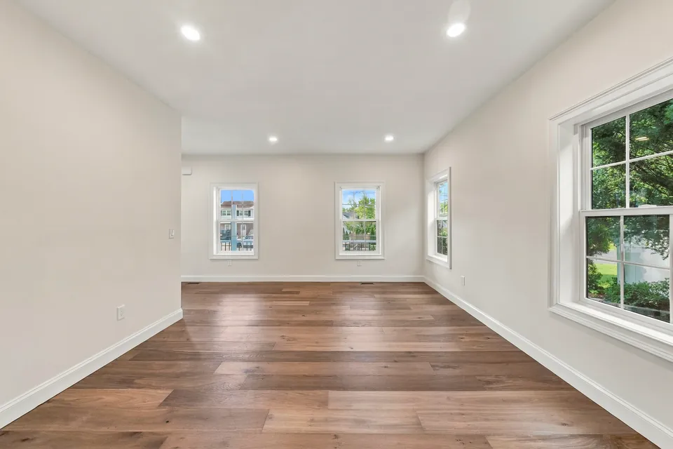 Bright living room with wide-plank hardwood floors and recessed lights